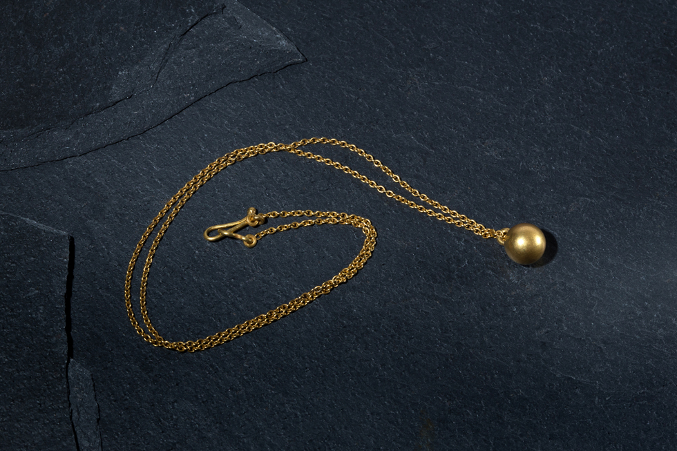 Gold ball on gold chain — Yves Gratas
